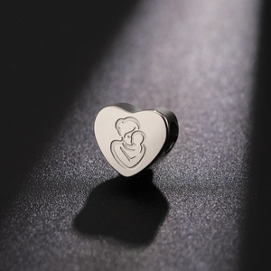 Polished heart-shaped stainless steel charm with detailed mother and child engraving