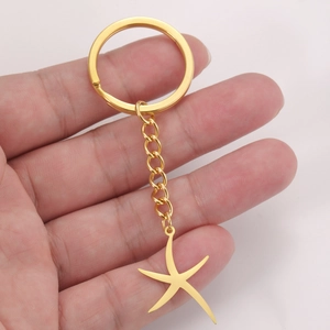 Porte-clés en acier inoxydable doré avec pendentif étoile de mer dans la main