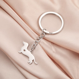 Polished stainless steel dachshund keychain with heart cutout on champagne silk fabric