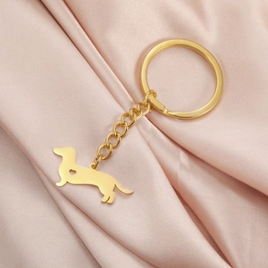 Polished gold stainless steel dachshund keychain with heart cutout on satin fabric