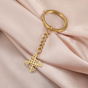 Golden hollowed windmill pendant keychain with O-chain on champagne silk background