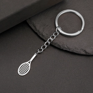 Porte-clés raquette de tennis en acier inoxydable argenté sur fond de pierre foncée