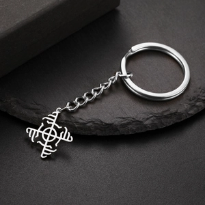 Close-up of stainless steel keychain with hollow Nordic Viking rune pendant on a stone background