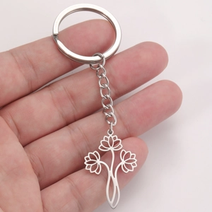 Porte-clés pendentif lotus ajouré en acier inoxydable argenté tenu en main