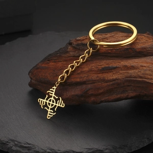 Macro shot of gold stainless steel Viking compass pendant on a rustic wooden block