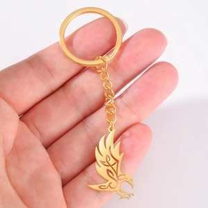 Polished gold stainless steel keychain featuring a hollow-out flying crow raven pendant