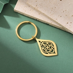 Macro de porte-clés doré avec pendentif goutte ciselé et détails fins en métal vintage