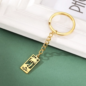 Vue détaillée du porte-clés doré en acier inoxydable avec pendentif palmier et vagues