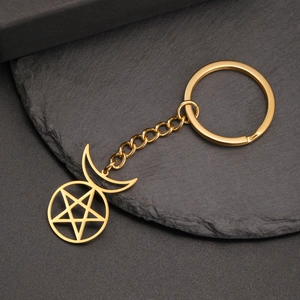 Detail of a gold stainless steel keychain with a pentagram and crescent moon pendant