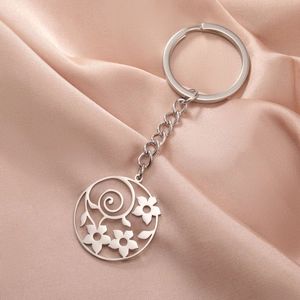 Detail view of silver stainless steel keychain featuring hollow floral circular pendant