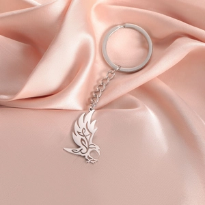 Detailed macro view of eagle pendant with silver finish on pink satin fabric background