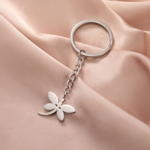 Polished silver stainless steel dragonfly keychain with mirror finish on pink silk background