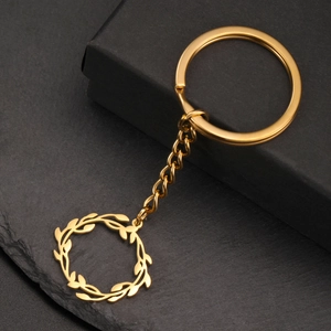 Détail d'un pendentif couronne en acier doré sur un fond élégant en pierre noire