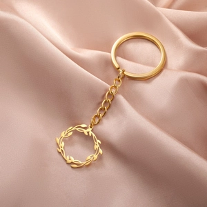 Détail d'un porte-clés doré en acier inoxydable avec pendentif couronne sur soie