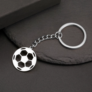 Détail d'un pendentif de football creux en acier inoxydable poli sur un porte-clés métal