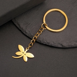 Macro shot of polished gold dragonfly pendant keychain with smooth metallic finish