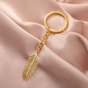 Polished gold stainless steel keychain featuring a geometric hollow leaf pendant on silk