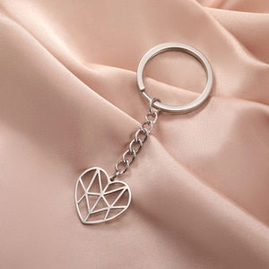 Minimalist silver stainless steel keychain with hollow heart pendant on pink satin