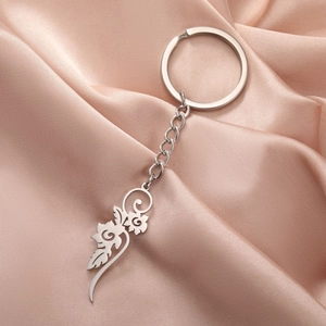 Silver hollow flower pendant keychain in stainless steel on a soft pink satin backdrop