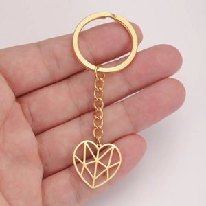 Detail of hand holding a golden hollow heart keychain with stainless steel link chain