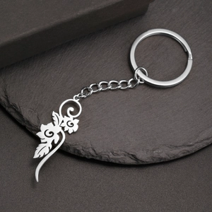 Macro detail of silver stainless steel keychain featuring a hollow floral vine pendant