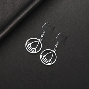 Detalle de los pendientes colgantes geométricos de plata sobre un fondo de cuero negro