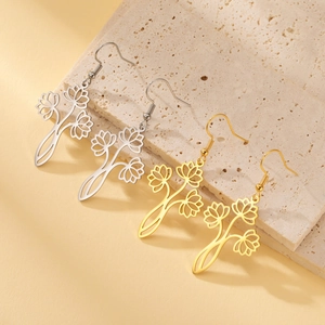 Detail of silver and gold bohemian lotus drop earrings on natural stone surface