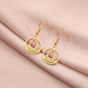 Detalle de pendientes dorados elemento agua sobre un elegante tejido de raso rosa