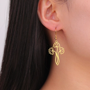 Close-up of golden stainless steel hollow lotus flower charm earrings worn by a model