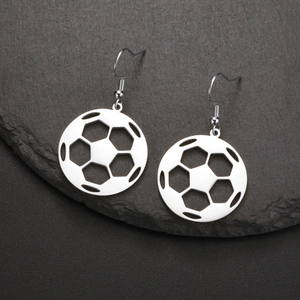 Detailed close-up of soccer ball hollow drop earrings on a dark stone texture
