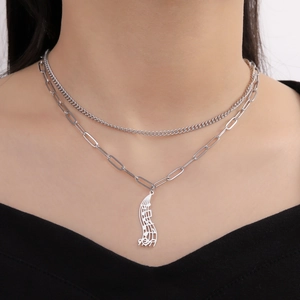 Close-up of double-layered stainless steel necklace featuring a musical note pendant