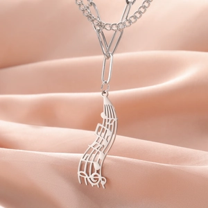 Detailed shot of silver music note pendant on a modern paperclip and link chain