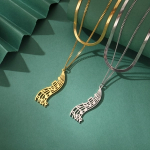 Close-up of gold and silver musical note pendant necklaces with double-layered metal chains