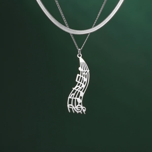 Detail view of layered stainless steel music note pendant with flat snake chain