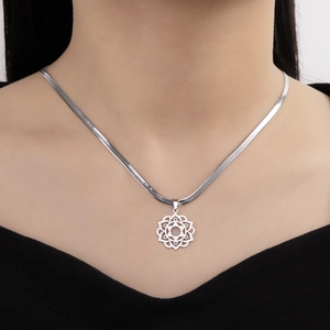 Detail showing the polished stainless steel snake chain and lotus mandala hollow pendant