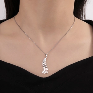 Detail of music note pendant on a stainless steel chain worn by a model