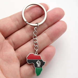 Porte-clés carte d'Afrique avec émail rouge, noir et vert et logo de poing, vue à la main