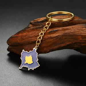 Detailed shot of golden Kosovo map keychain with blue and yellow enamel on dark wood