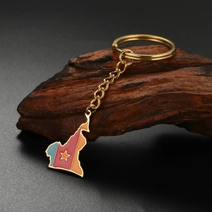 Macro shot of gold Cameroon map keychain with flag enamel colors on vintage wood background