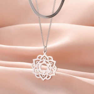 Detail view of silver hollow geometric floral pendant on a layered stainless steel chain