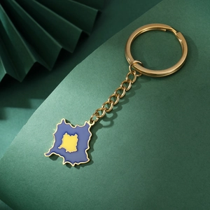 Macro shot of gold-plated Kosovo map keychain with blue and yellow enamel finish