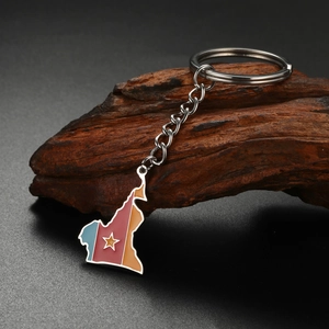 Detailed shot of Cameroon map keychain with flag colors on a rustic wooden stand