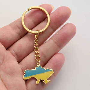Detail of hand-held gold titanium steel Ukraine map keychain with blue and yellow oil drip