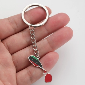 Detail showing hand holding the Saint Kitts and Nevis flag map pendant keychain