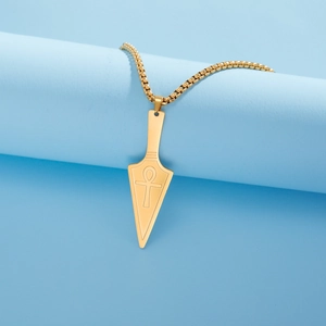 Detailed macro of golden Ankh symbol engraved on a stainless steel arrowhead pendant necklace