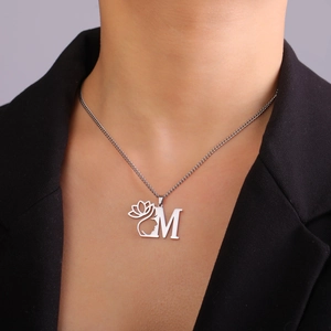 Collier en acier inoxydable argenté avec pendentif fleur de lotus et lettre M sur modèle