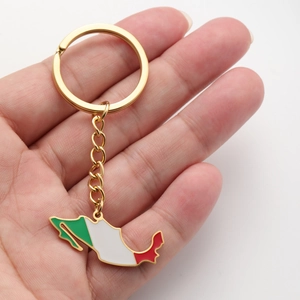 Détail d'un porte-clés carte du Mexique doré avec émail vert blanc et rouge en main