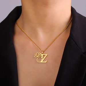 Gros plan du pendentif lettre Z doré avec lotus et visage porté sur un collier