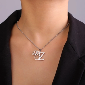 Détail du collier en acier argenté avec pendentif lettre Z, lotus et visage féminin