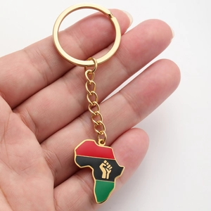 Détail du porte-clés carte d'Afrique doré avec émail rouge, noir et vert à la main